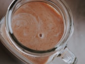 A macro shot of syrup being poured into a glass jar, highlighting its rich texture and color.