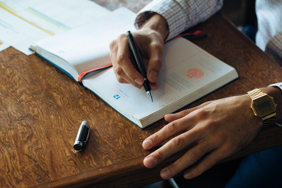 Person writing notes during a business consultation