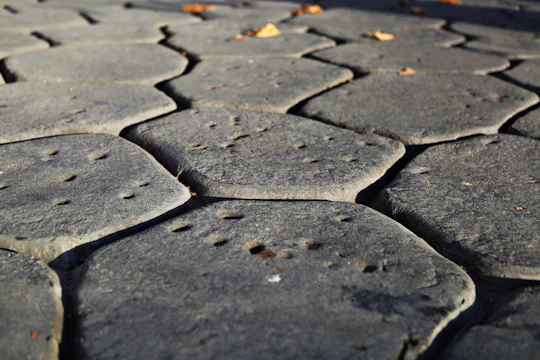 Close-up image of a stone patio gleaming after a thorough pressure wash, with sunlight casting soft shadows.