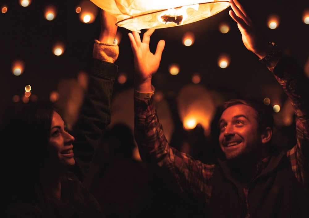 a group of people holding up a lit lantern