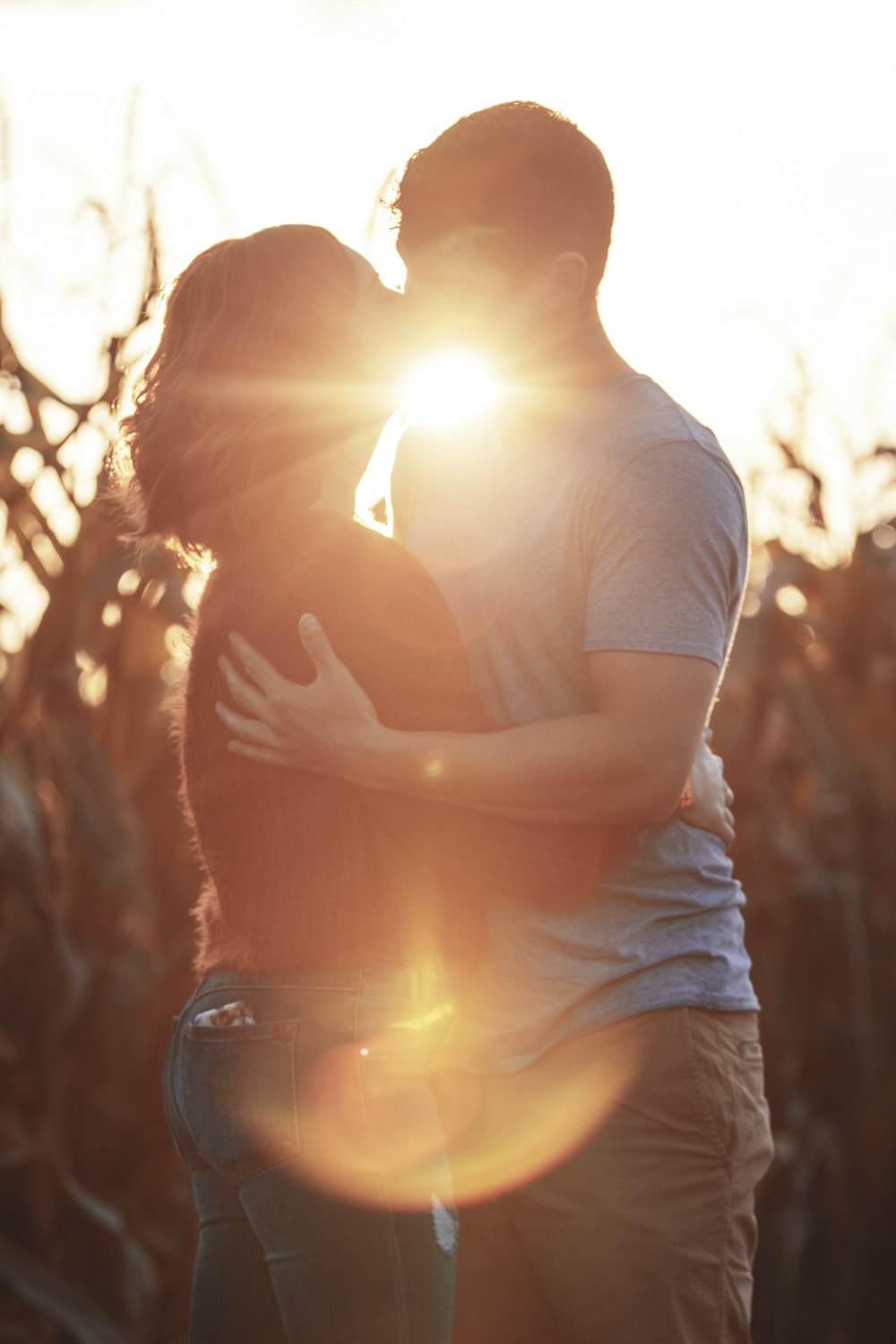 man and woman kissing during golden hour