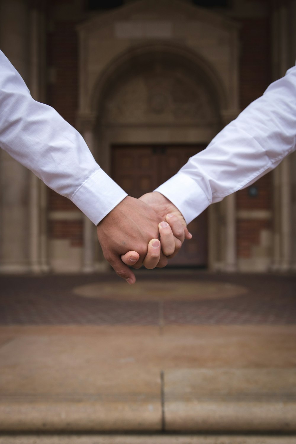 close-up photography of people holding hands during daytime