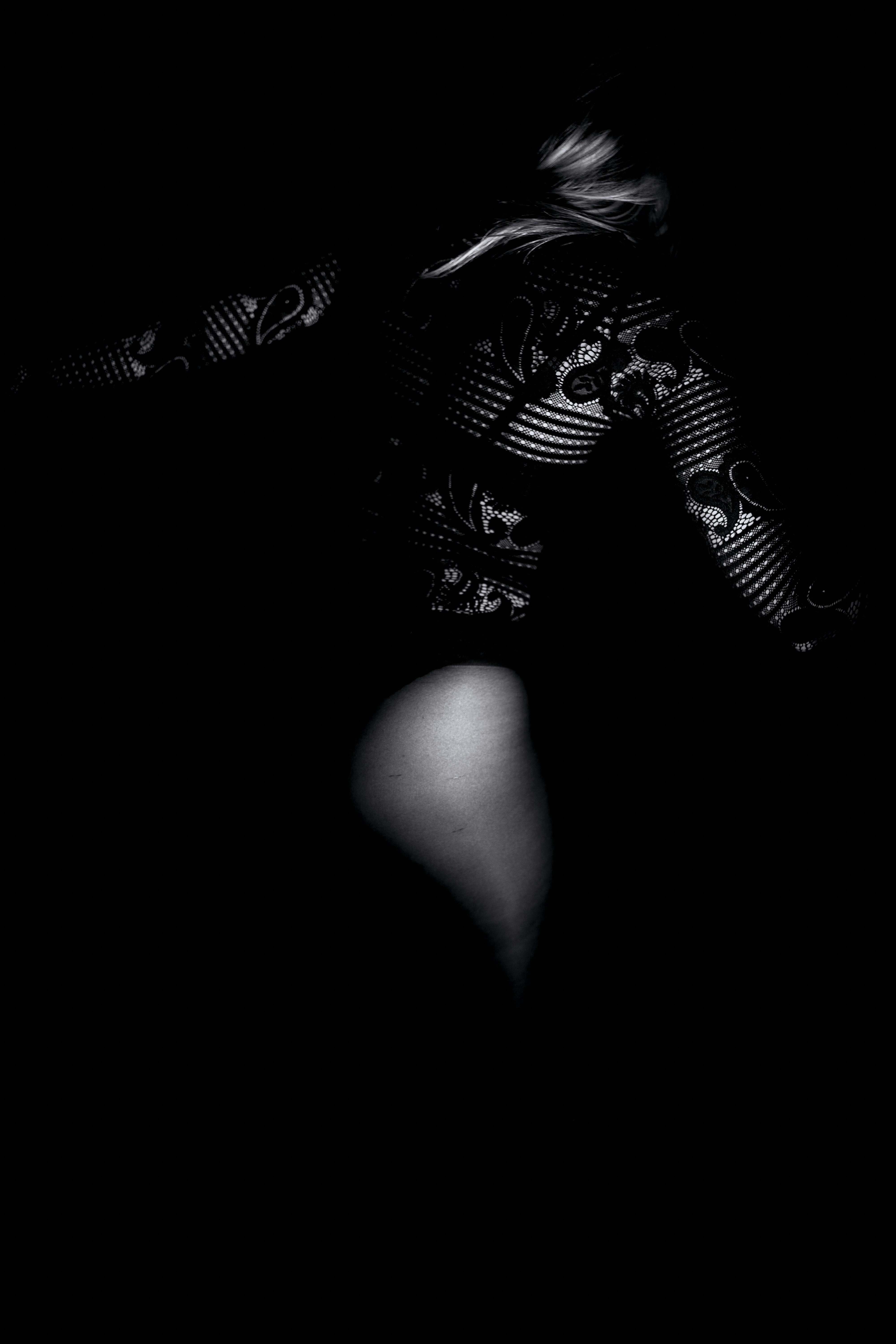 Una foto en blanco y negro de una mujer en la oscuridad