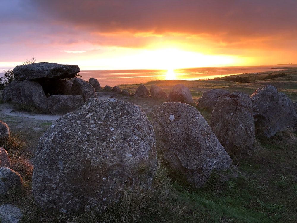 gray rocks near sea during sunset