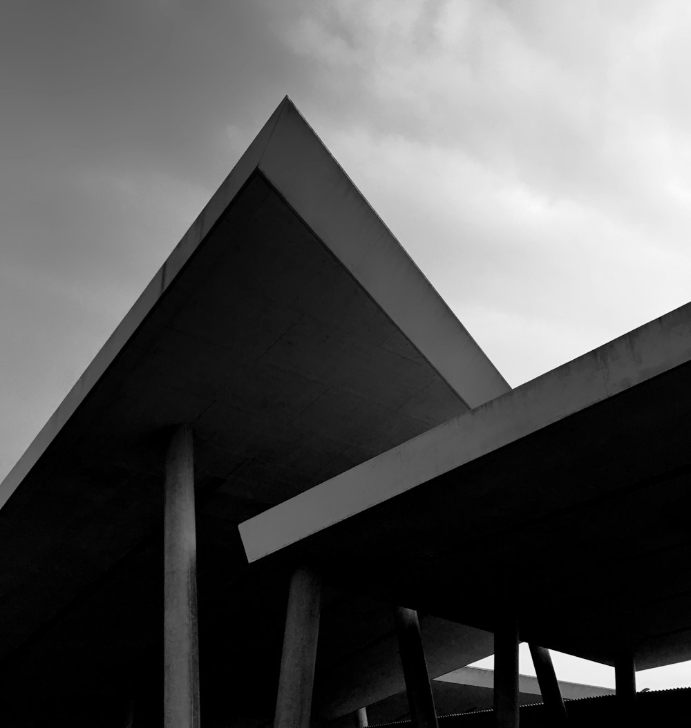 a black and white photo of a building under a cloudy sky