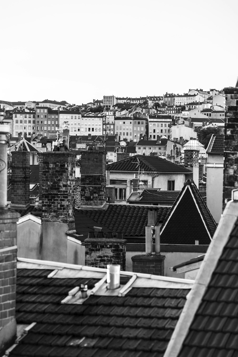 a black and white photo of rooftops in a city