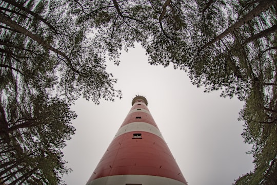 low angle photo of white and red lighthouse in Ameland Netherlands