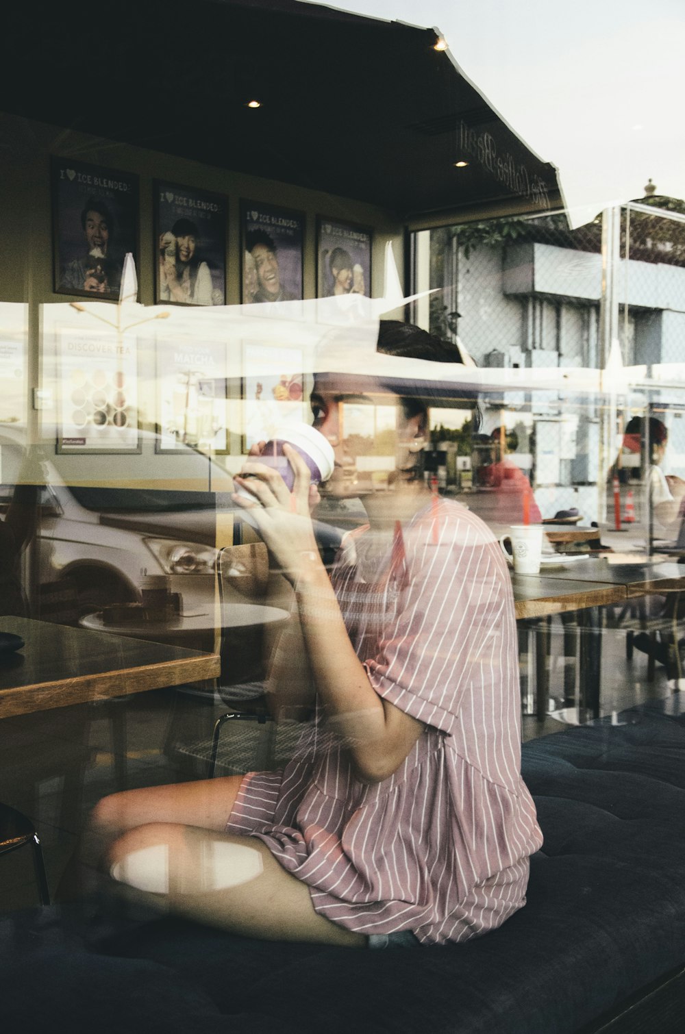 a woman sitting on the ground in front of a window