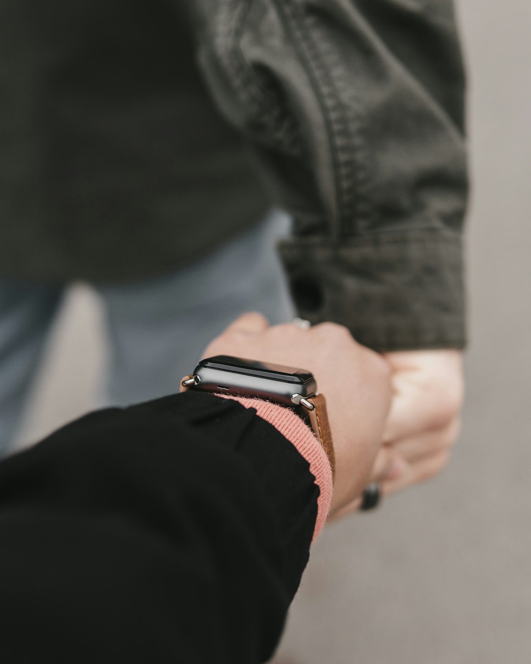 person wearing watch holding person's hand