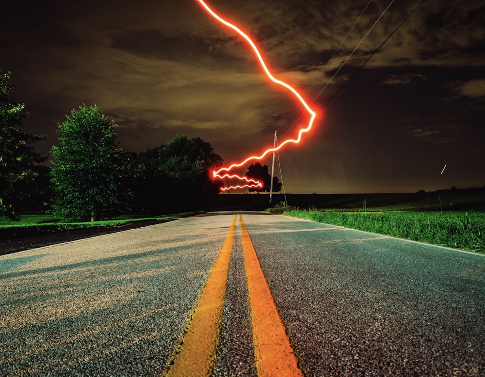 a long exposure photo of a road at night