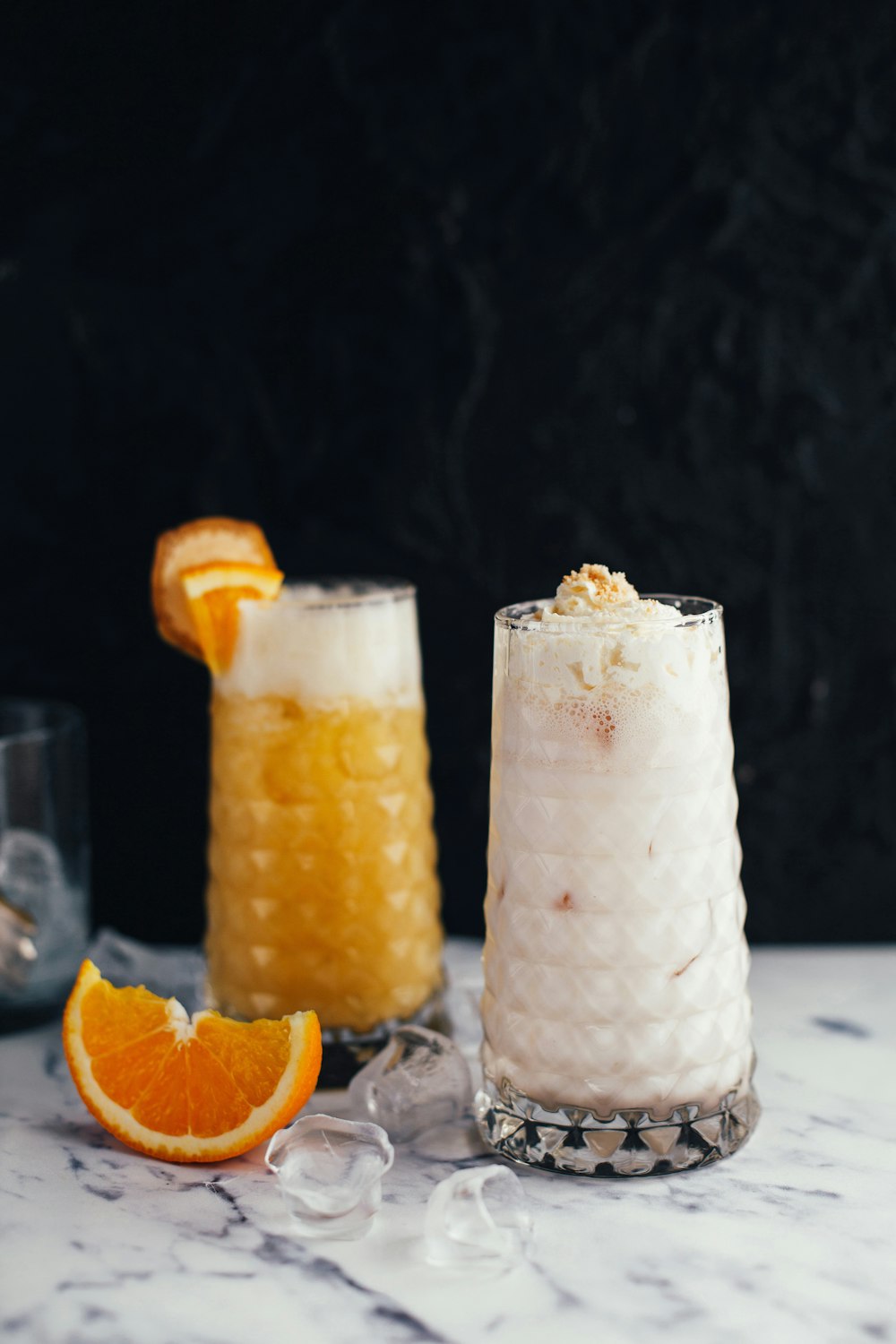 two clear drinking glasses with juice on table