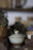 Close-up of a handmade stoneware cup with warm earthy tones on a wooden table.