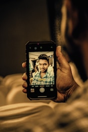 Close-up of a dermatologist taking a patient's photo with a smartphone in a bright clinic.