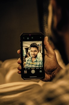 A person holding a smartphone capturing their face from three angles in bright natural light for skin analysis.
