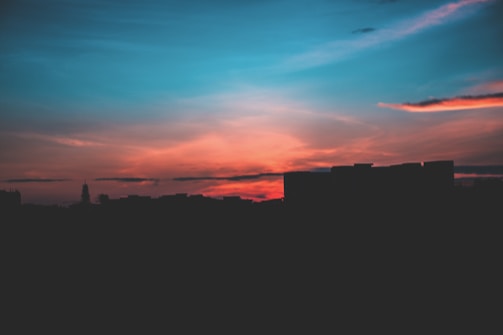 An artistic representation of a city skyline at sunset.