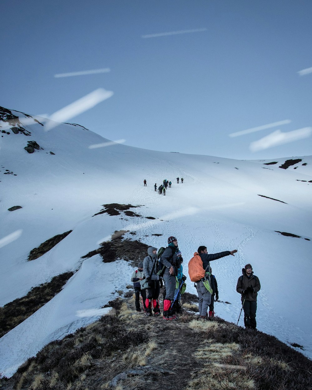 Personas de pie en la montaña cubierta de nieve durante el día