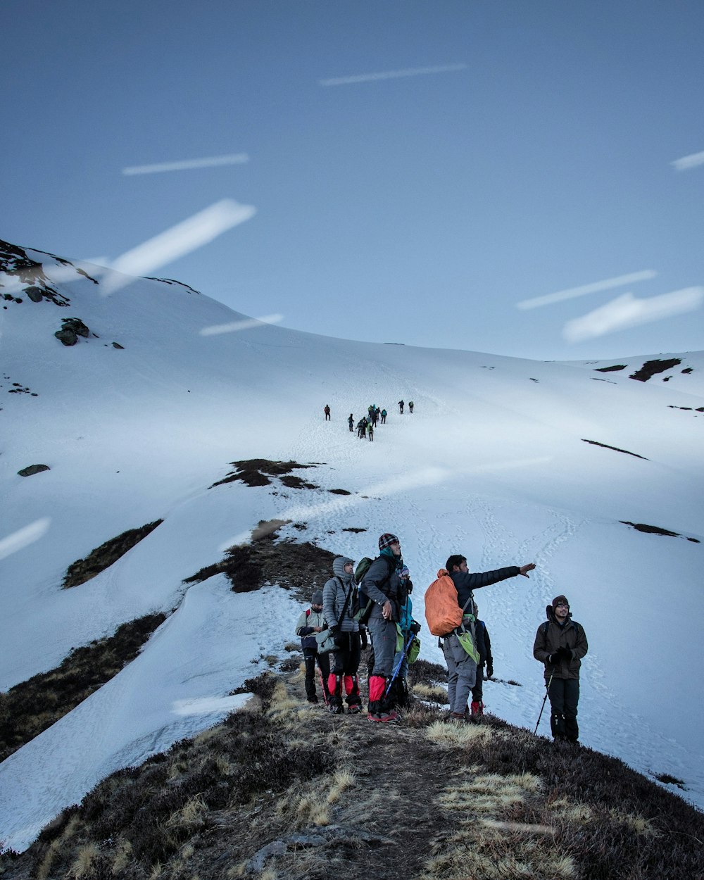 Persone in piedi sulla montagna innevata durante il giorno