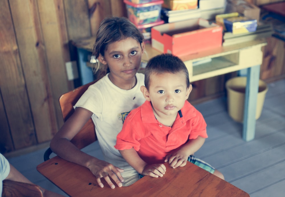 girl and boy sitting on armchair