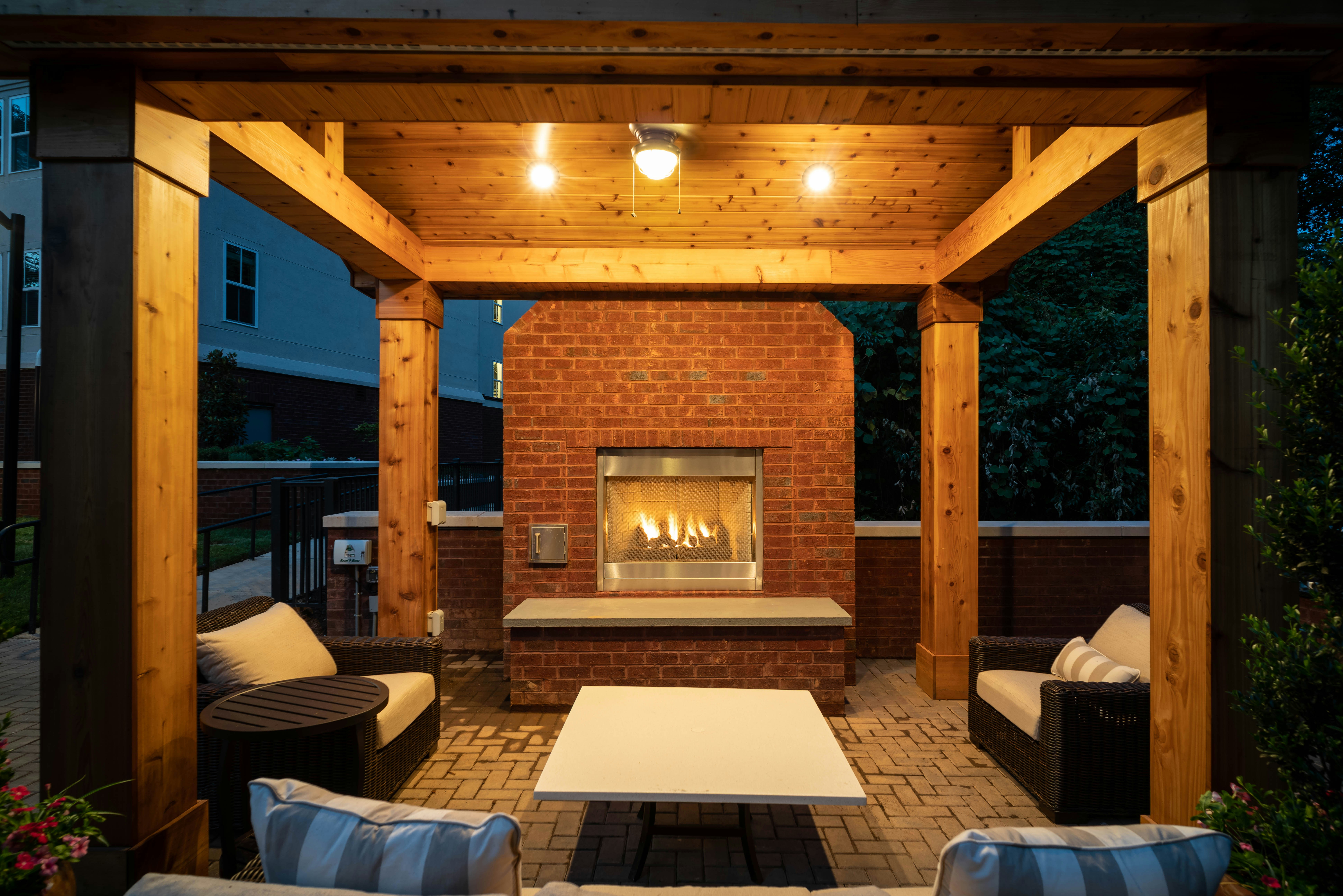 Custom outdoor fireplace feature under pavilion on patio with seating installed in Galveston