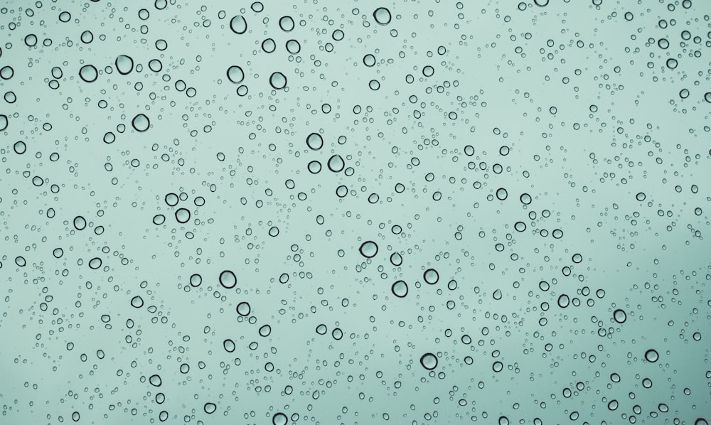 rain drops on a window with a blue sky in the background