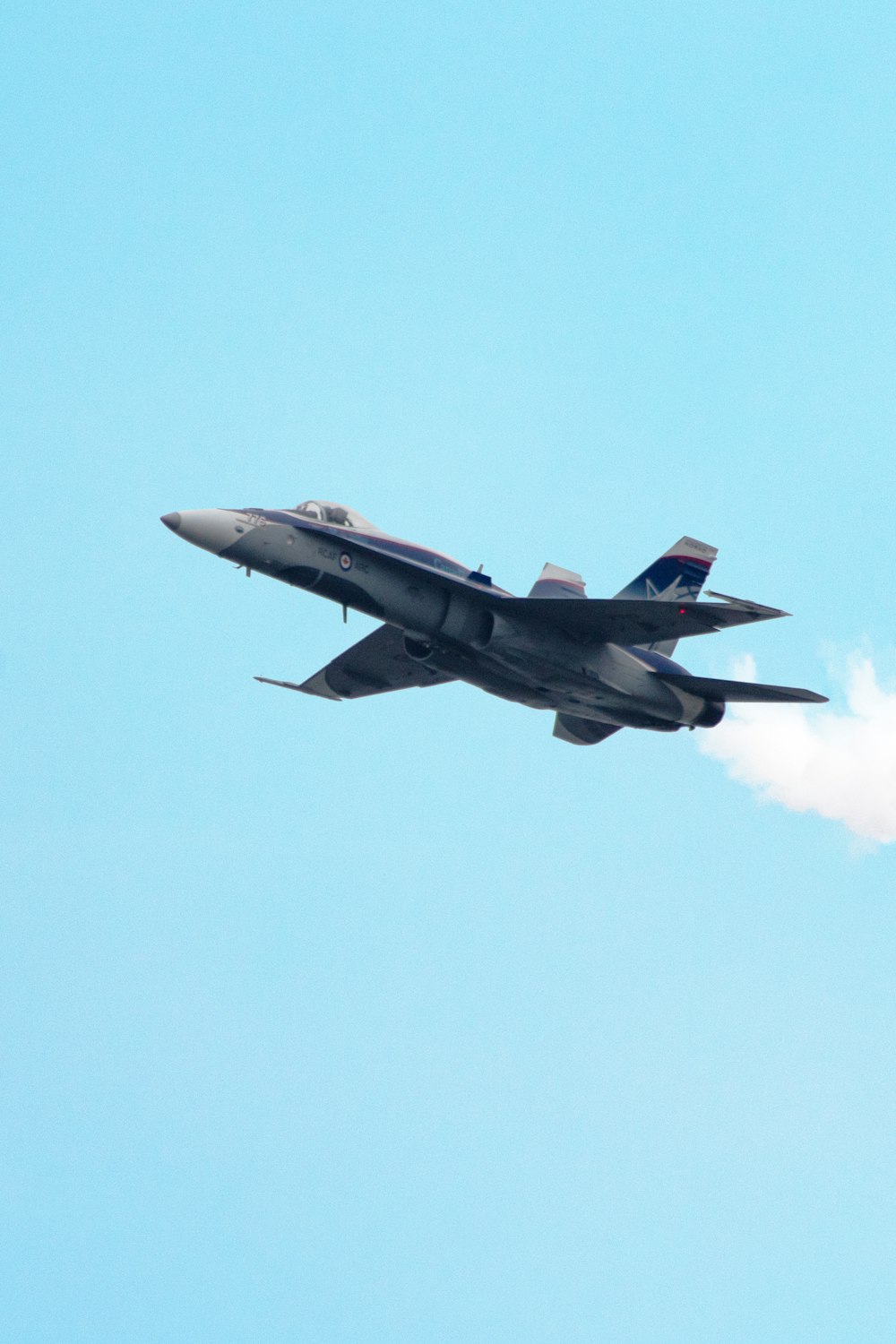 Fotografia de foco seletivo de avião de caça cinza no ar durante o dia