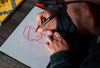 man drawing on white printer paper