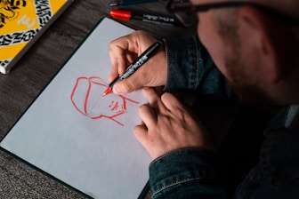 man drawing on white printer paper