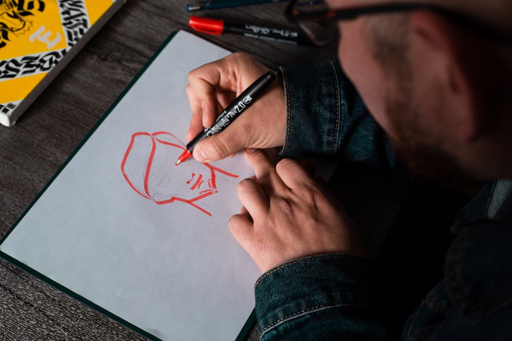 man drawing on white printer paper