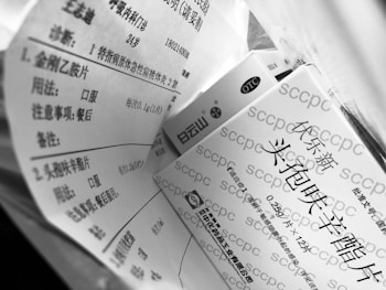 A black and white image shows multiple boxes with Chinese text printed on them, suggesting they are pharmaceutical products. The focus is on the packaging information which includes dosage and usage instructions.