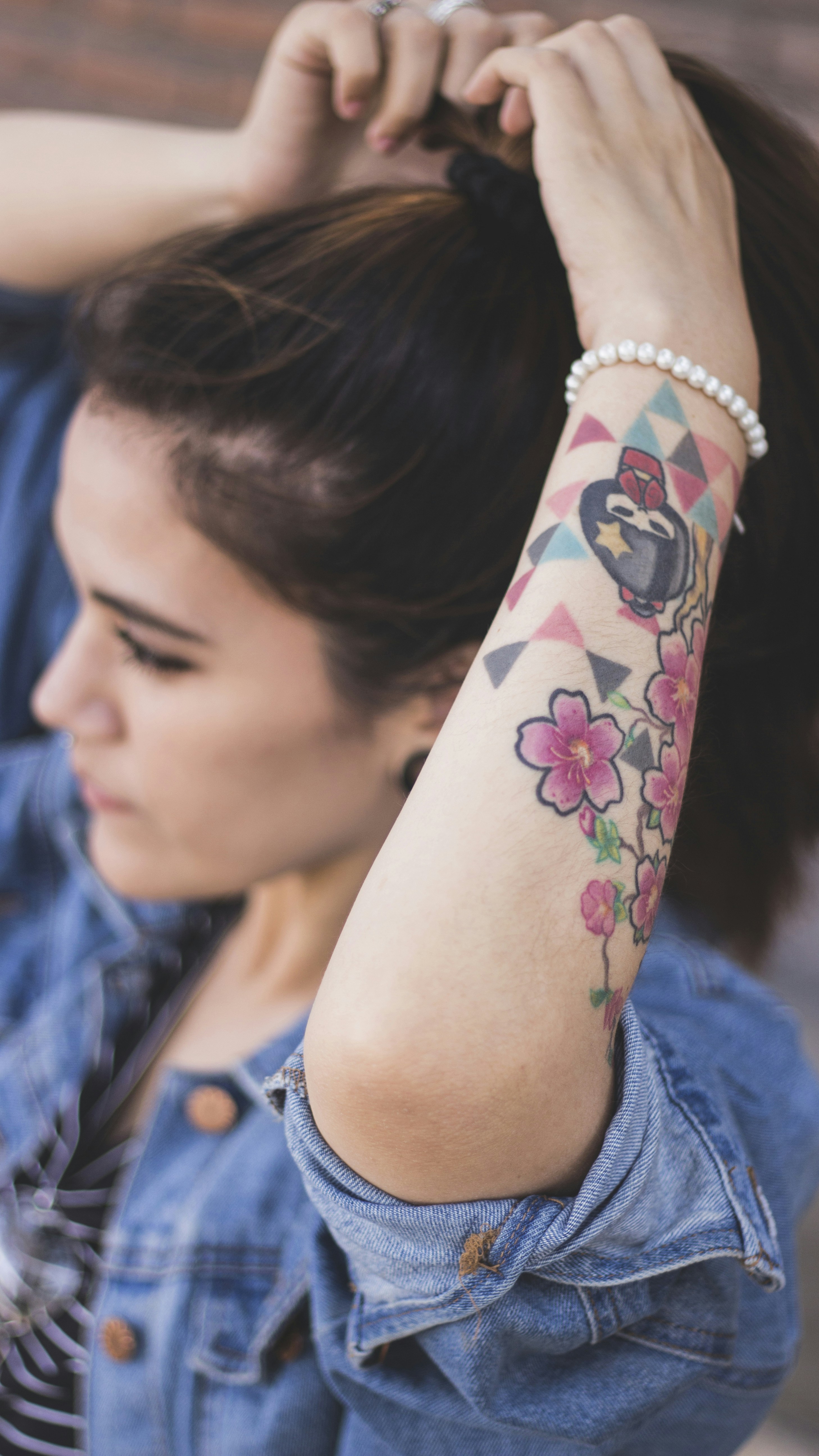 Woman Wearing Blue Button Up Jacket And Tying Hair Photo Free