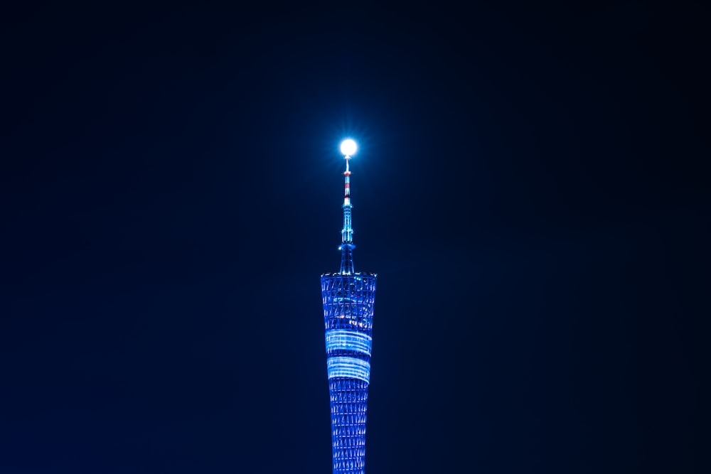 edifício alto de vidro transparente azul durante a noite