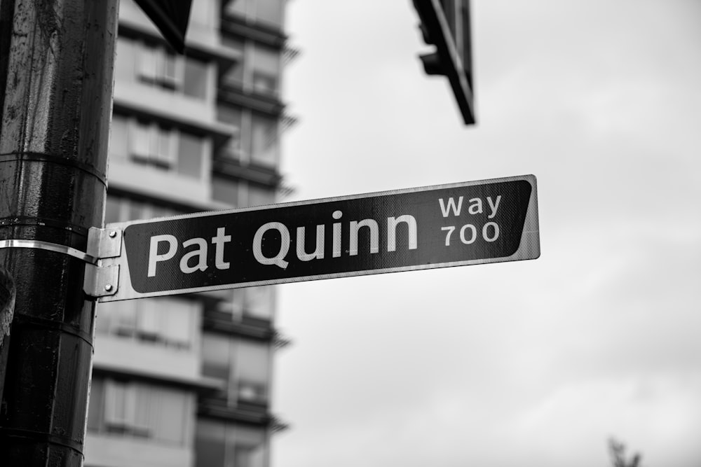 grayscale photography of Pat Quinn signage