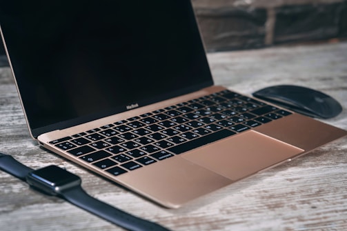 A sleek black laptop on a dark desk with futuristic digital overlays.