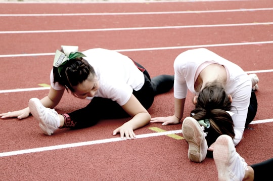 two women splitting legs on running track in Heidelberg Germany