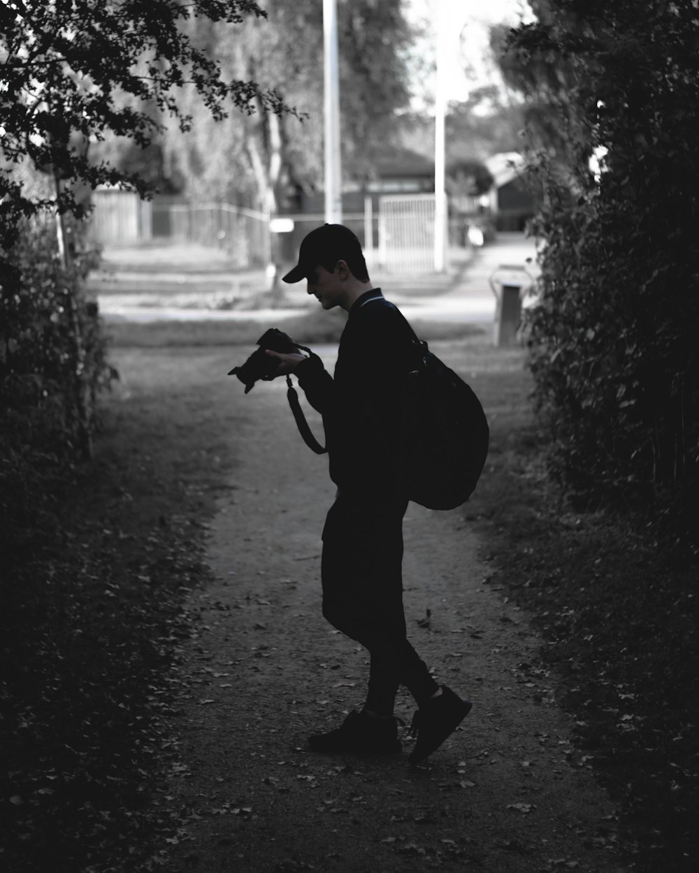 man holding camera while standing on path