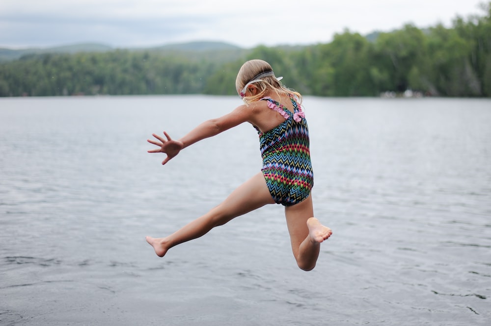 fille sautant sur le plan d’eau