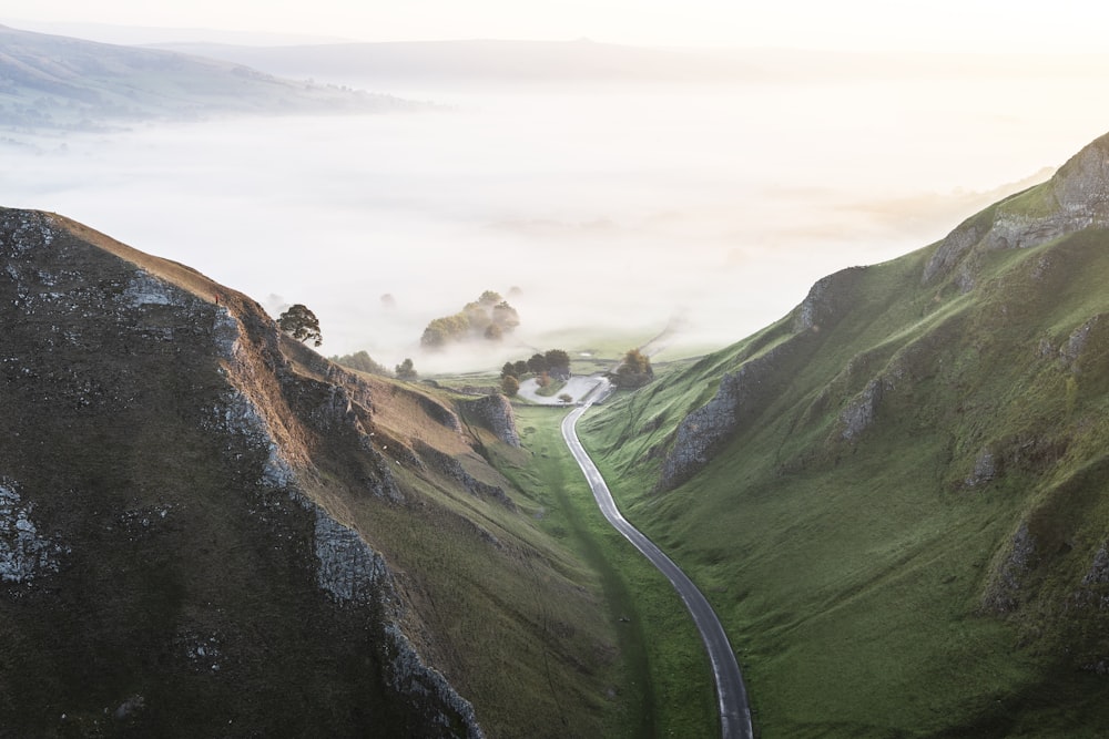 road between grassy mountains during daylight