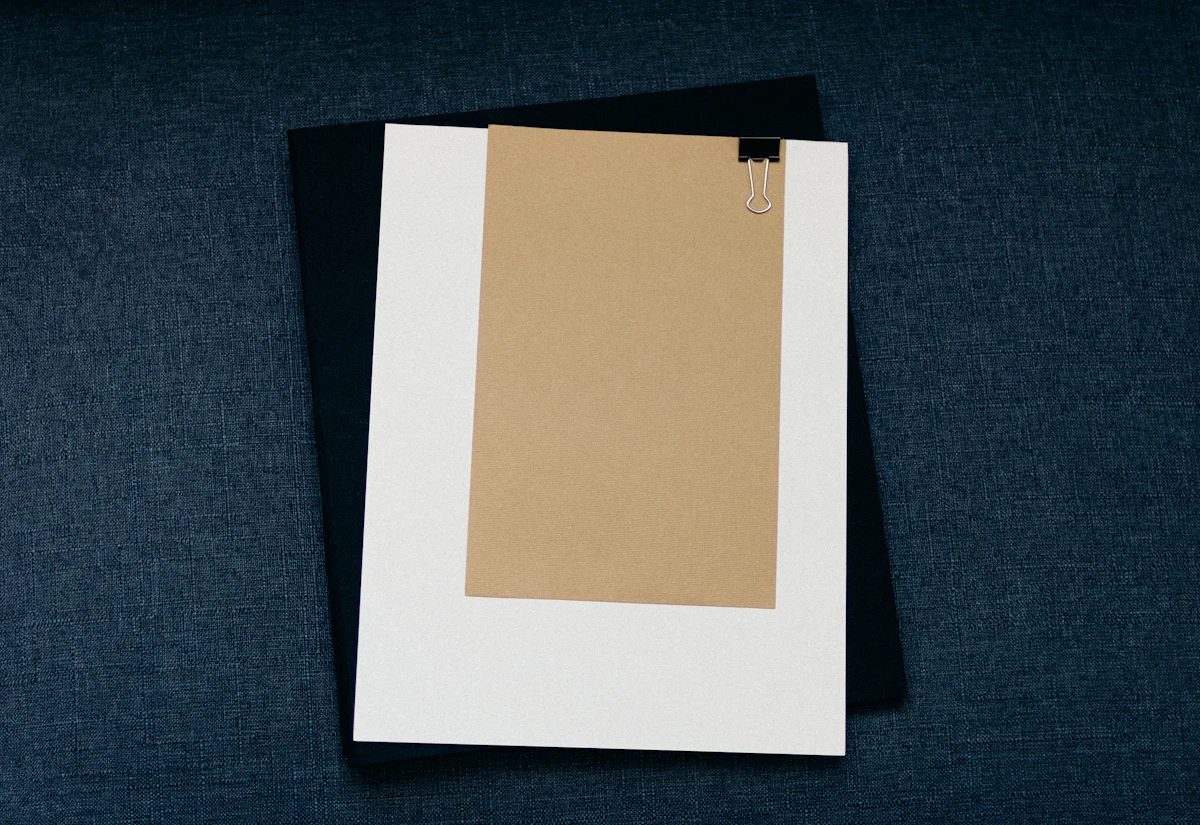 Papan jepit putih dengan kertas di atas permukaan hitam