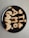 A black plate holds cookies shaped into letters and symbols, forming a message and including heart shapes. The cookies have a golden-brown color, typical of baked goods.