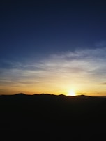 A cinematic shot of a serene sunset over a mountain range, edited for dramatic color grading.