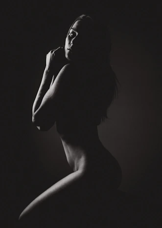 Gentle shadows highlighting the gentle curves of a woman’s side profile in neutral tones.