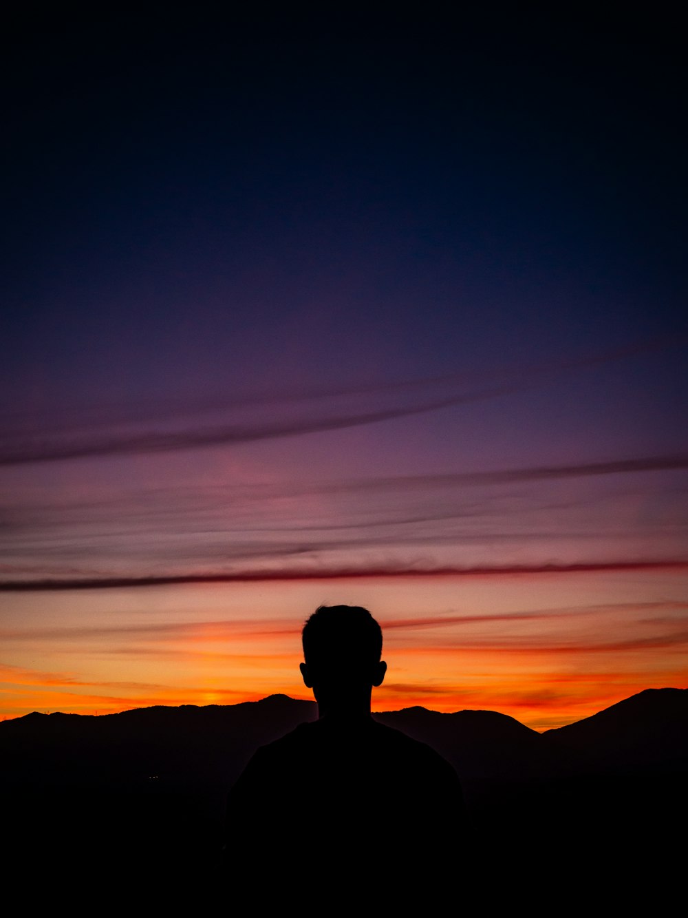 Silhouette eines Mannes, der mit Berg am Horizont steht