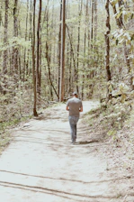 A man walking from shadowed woods into a bright golden sunrise, symbolizing new beginnings.