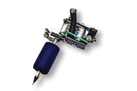 A colorful tattoo machine resting on a travel journal beside a map