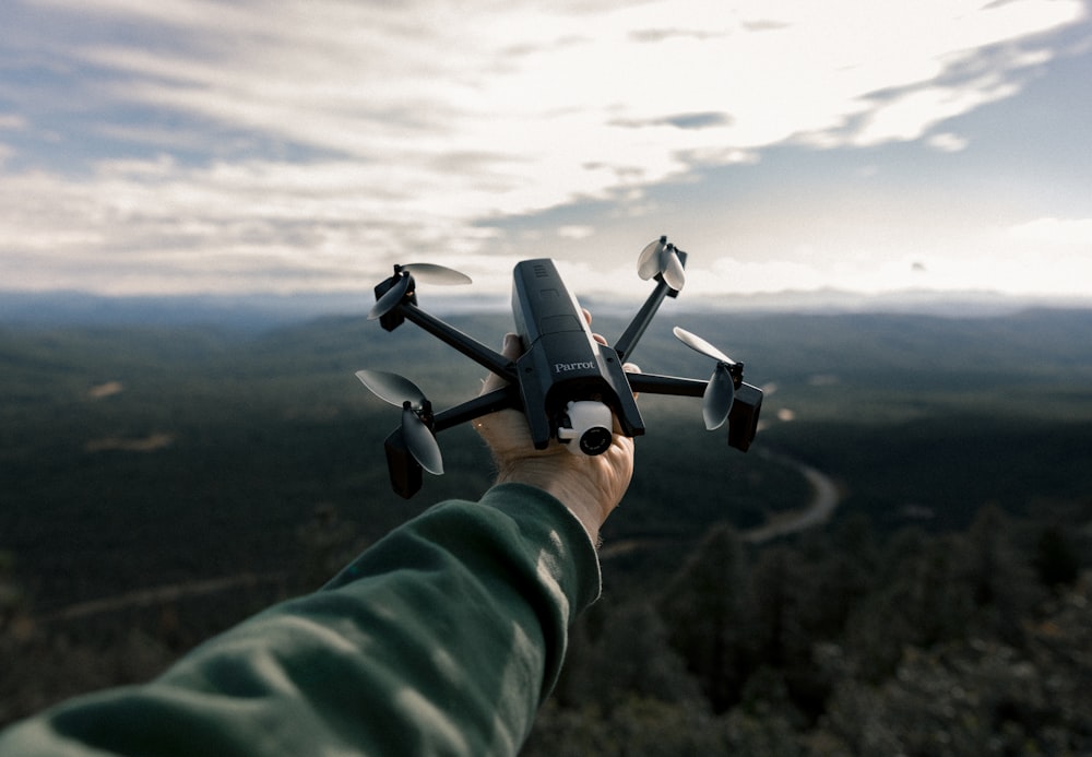 person holding black and gray drone