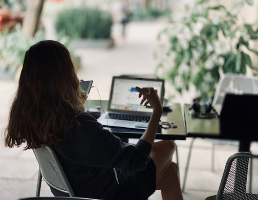 woman sitting on chair in front of table with laptop