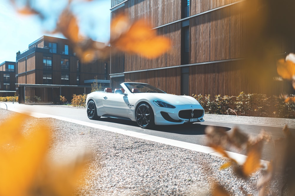 white convertible parked near brown wall