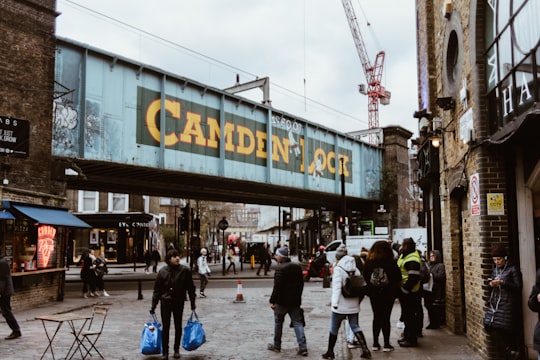 man carrying blue plastic bag in Camden Lock United Kingdom