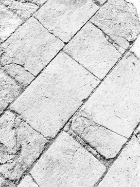 Weathered stone tiles with visible cracks and rough textures, arranged in a diagonal pattern across the surface.