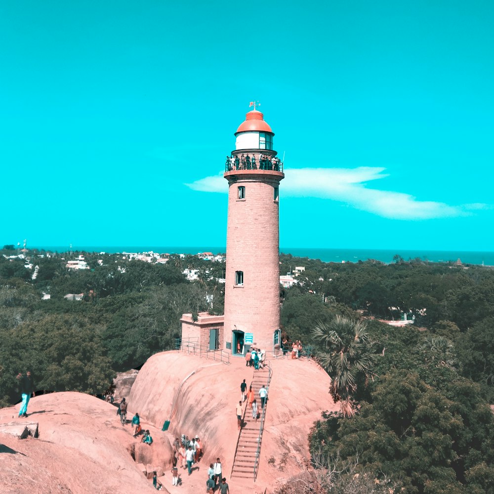 people on gray and white lighthouse